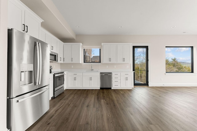 kitchen with white cabinetry, light countertops, a sink, and stainless steel appliances
