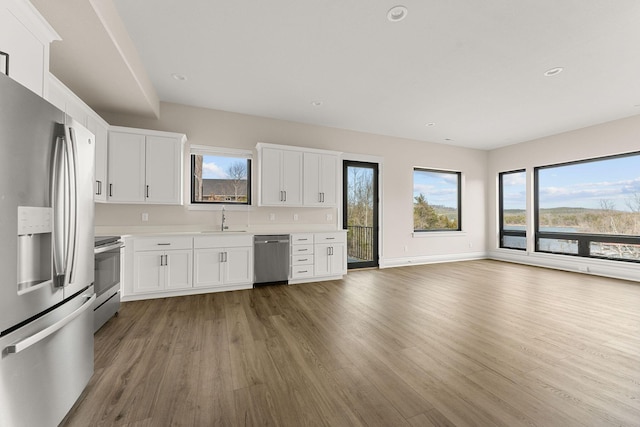 kitchen with light countertops, a sink, stainless steel appliances, and light wood finished floors