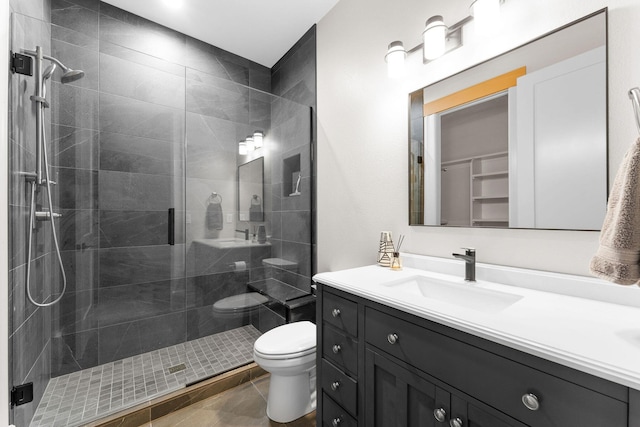full bath with toilet, vanity, and a shower stall
