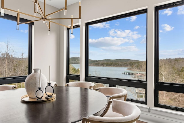 dining space featuring a wealth of natural light, a water view, and a chandelier