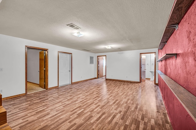 2505 Courtney Pl, West Plains, MO 65775 - finished basement with light wood finished floors, a textured ceiling, and baseboards