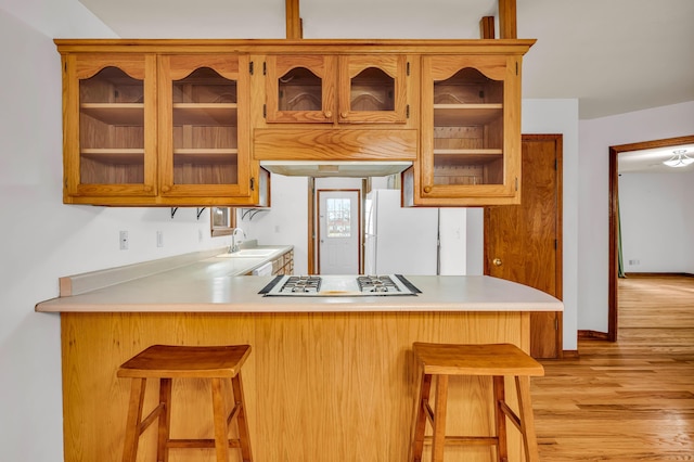 2505 Courtney Pl, West Plains, MO 65775 - kitchen with gas stovetop, light countertops, a sink, glass insert cabinets, and a peninsula