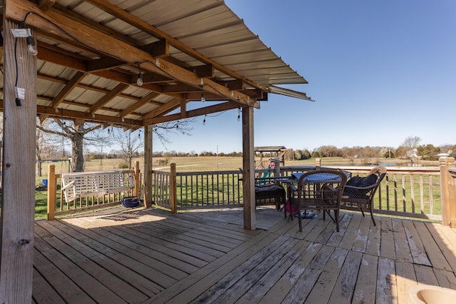 wooden deck with a rural view and a lawn