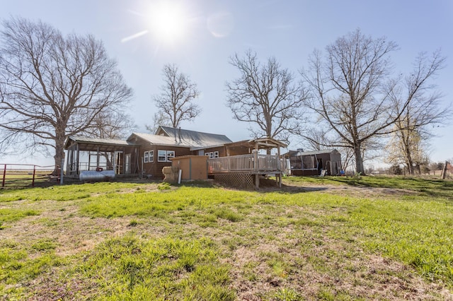 view of yard featuring a wooden deck, an outbuilding, and fence