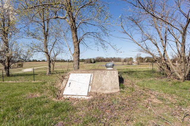 view of storm shelter featuring a rural view and a yard