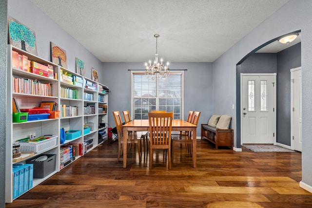 445 E Sequoia St, Republic, MO 65738 - dining space with arched walkways, a chandelier, wood finished floors, a textured ceiling, and baseboards