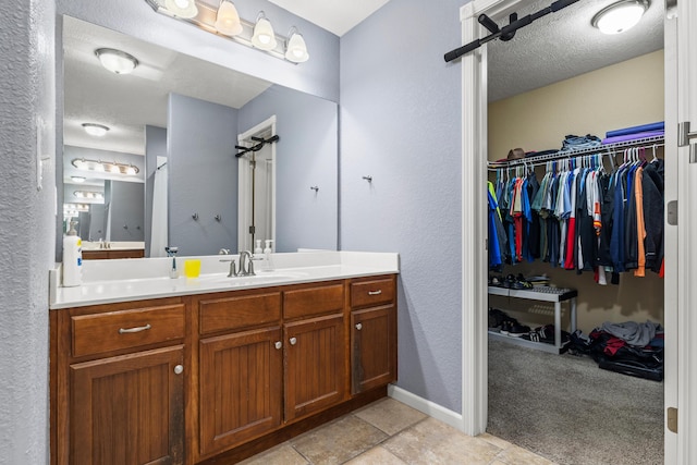 445 E Sequoia St, Republic, MO 65738 - full bathroom with vanity, a textured wall, a walk in closet, and a textured ceiling