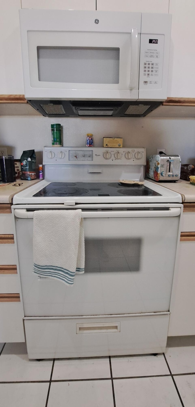 120 Spring Creek Ct Unit B1-U34, Branson, MO 65616 - kitchen with white cabinetry, light countertops, light tile patterned flooring, and white appliances