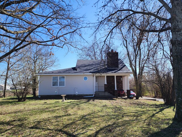 view of front of property with a chimney and a front lawn