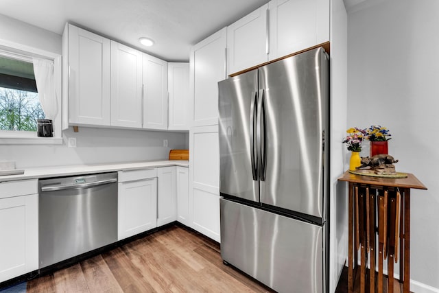 504 Brown St, Branson, MO 65616 - kitchen featuring appliances with stainless steel finishes, wood finished floors, light countertops, and white cabinets