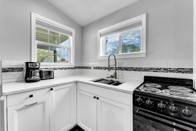 504 Brown St, Branson, MO 65616 - kitchen with black range with electric cooktop, a sink, tasteful backsplash, white cabinetry, and lofted ceiling