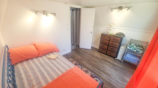 bedroom with baseboards and wood finished floors