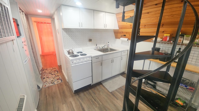 kitchen with electric range, a sink, white cabinetry, and wood finished floors