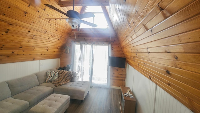 living room with lofted ceiling, wood walls, and wood finished floors