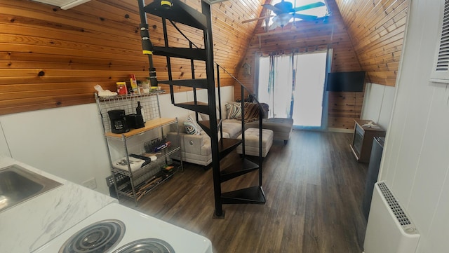 living area with wood walls, vaulted ceiling, wooden ceiling, radiator heating unit, and wood finished floors