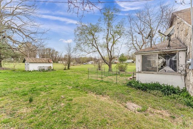 view of yard with fence, an outdoor structure, and a storage shed