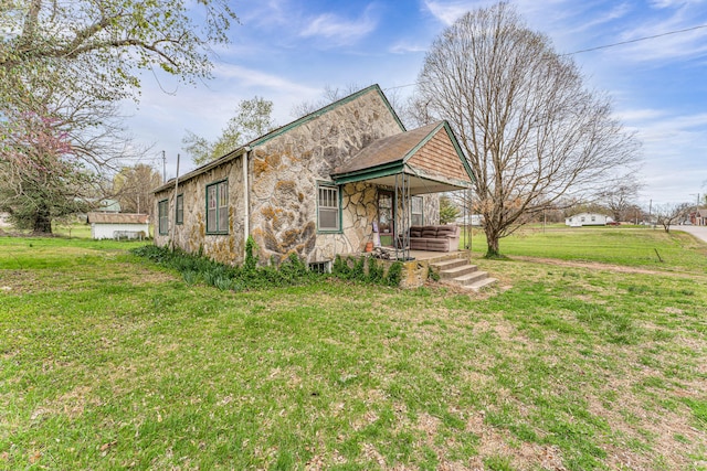 view of front of home with a front yard and stone siding