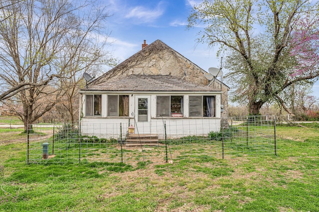 view of front facade featuring a front yard, a sunroom, and fence