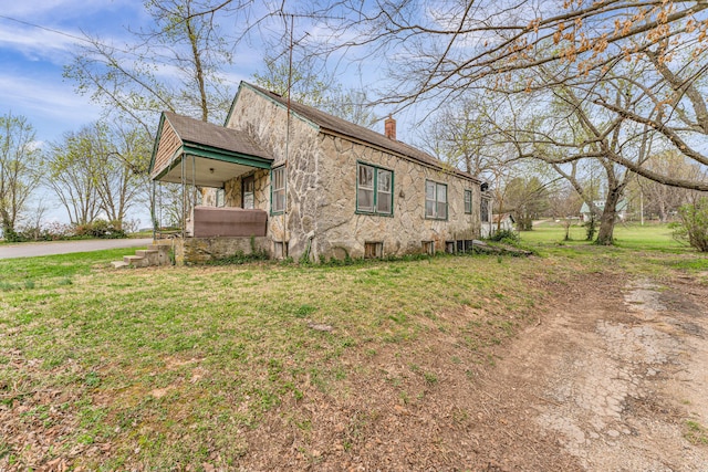 view of front of home featuring a chimney and a front yard