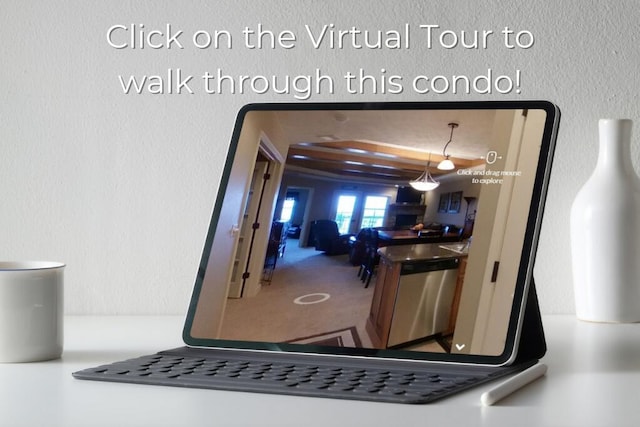 interior space with stainless steel dishwasher, a textured wall, and carpet flooring