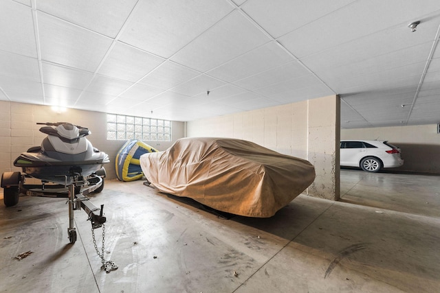 bonus room featuring concrete block wall and concrete floors