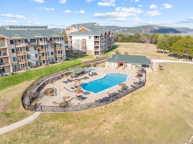 community pool with a mountain view, fence, and a patio