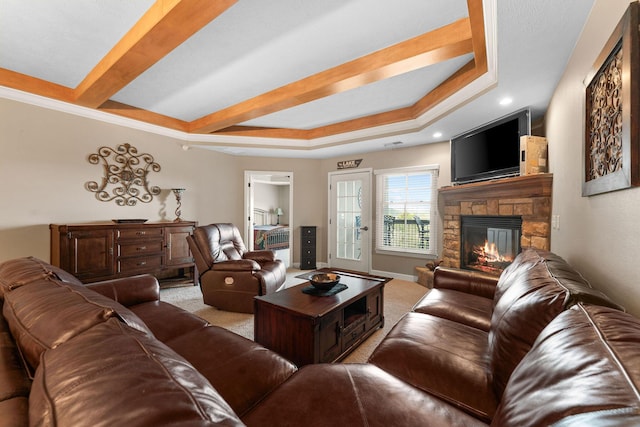 living room featuring a stone fireplace, baseboards, carpet, and a raised ceiling