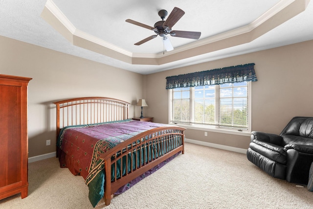 bedroom with a tray ceiling, baseboards, light colored carpet, and crown molding