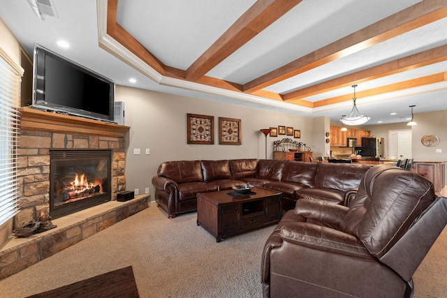 living area with visible vents, a fireplace, a raised ceiling, beam ceiling, and light carpet