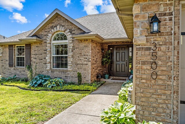 3500 W Sagamont St, Springfield, MO 65807 - entrance to property featuring roof with shingles, brick siding, and a lawn