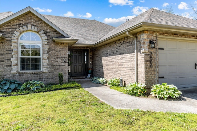 3500 W Sagamont St, Springfield, MO 65807 - property entrance with a yard, brick siding, a shingled roof, and a garage