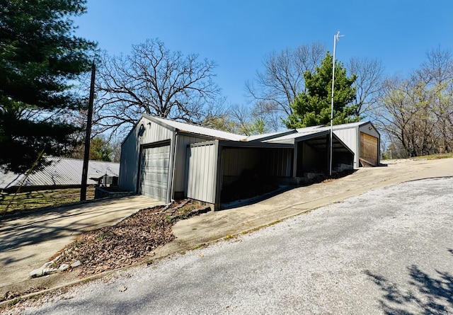view of outdoor structure featuring driveway and an outbuilding