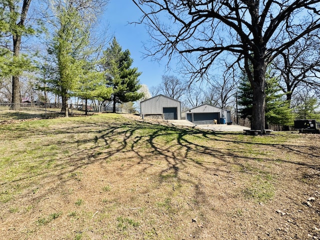 view of yard with an outbuilding, fence, and a garage