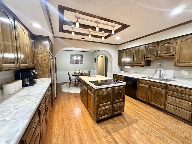 kitchen with light wood-style floors, a sink, a raised ceiling, black appliances, and arched walkways