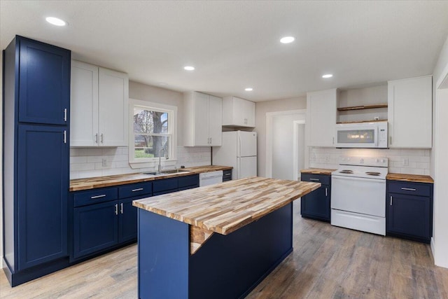 kitchen with blue cabinetry, white appliances, butcher block countertops, a sink, and light wood-style floors