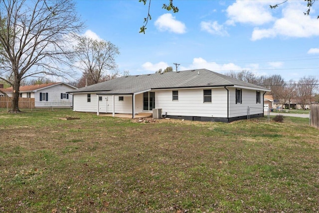back of property with roof with shingles, fence, crawl space, central AC, and a lawn