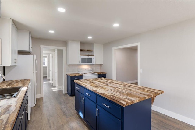 kitchen featuring wooden counters, white cabinetry, blue cabinetry, and white appliances