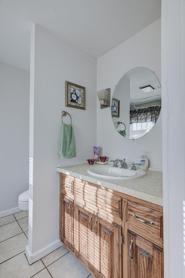 bathroom featuring tile patterned floors, vanity, toilet, and baseboards
