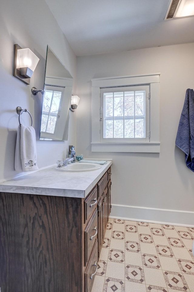 bathroom with vanity, baseboards, and visible vents