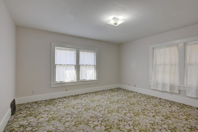 unfurnished room featuring carpet floors and baseboards