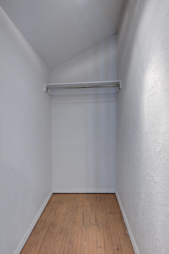 spacious closet featuring vaulted ceiling and hardwood / wood-style flooring