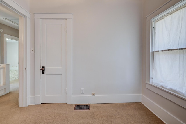 carpeted empty room with baseboards, visible vents, and a healthy amount of sunlight