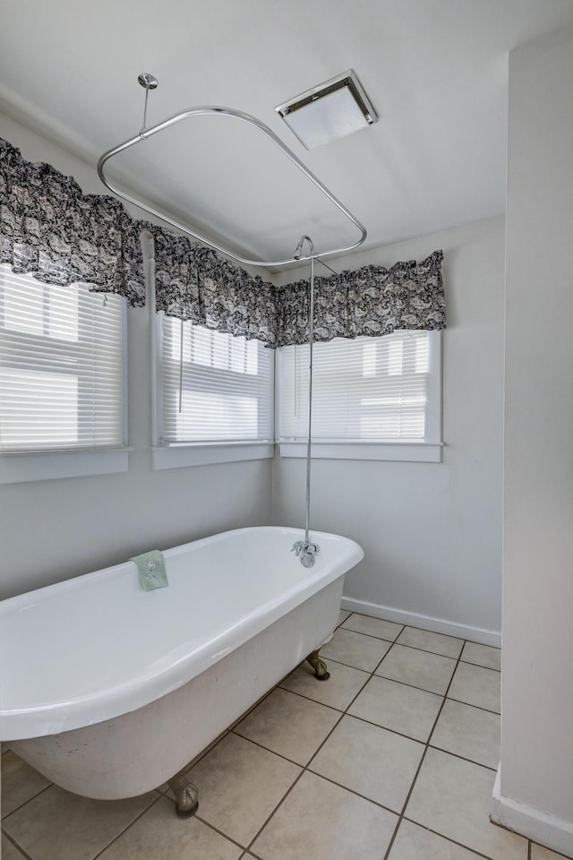 full bathroom with a soaking tub, tile patterned flooring, baseboards, and visible vents