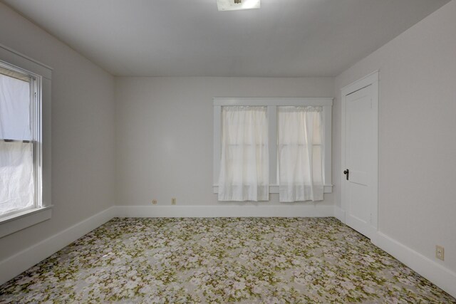 carpeted spare room featuring baseboards