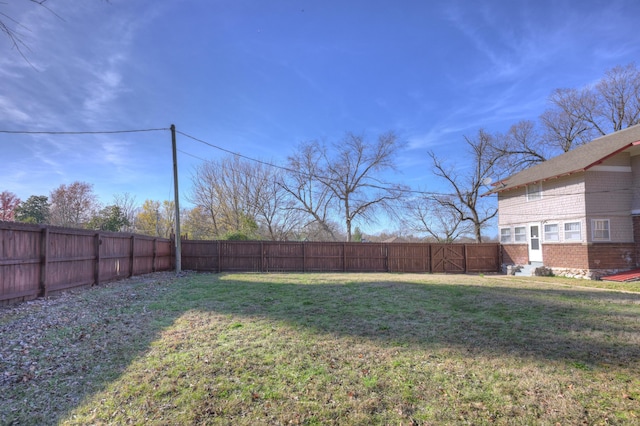 view of yard featuring a fenced backyard and entry steps