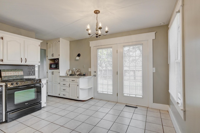 kitchen featuring a notable chandelier, light tile patterned floors, built in microwave, white cabinets, and black electric range