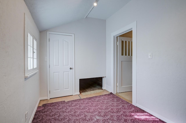 interior space with baseboards and vaulted ceiling
