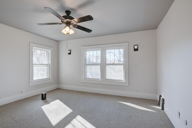 carpeted empty room with baseboards and ceiling fan