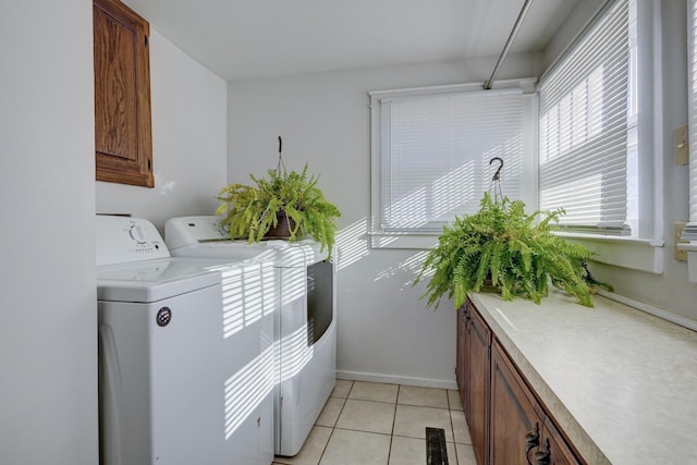 laundry room with independent washer and dryer, light tile patterned floors, baseboards, visible vents, and cabinet space