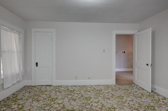 unfurnished room featuring baseboards and carpet